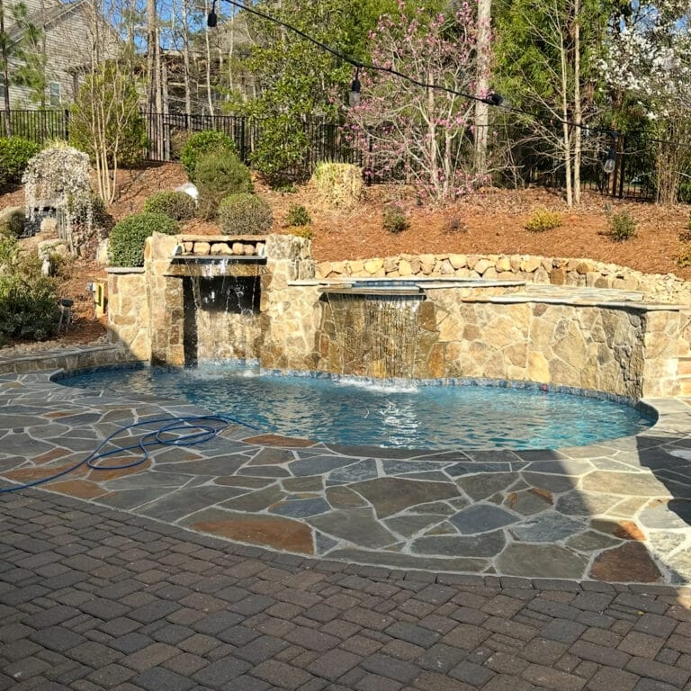 Gunite in-ground freeform pool with grotto and raised spa in Charlotte North Carolina