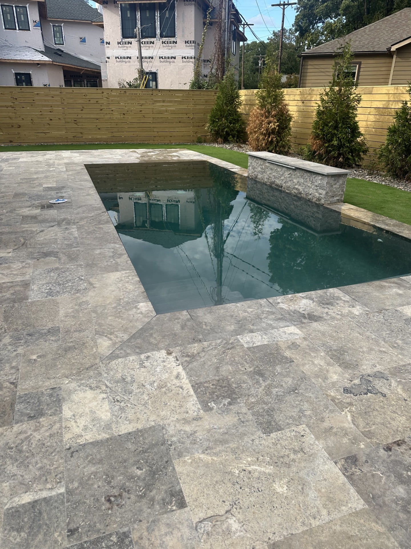 In-progress custom gunite pool construction with travertine deck for Charlotte area home builder project